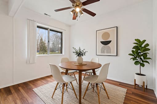 A dining room with a table and chairs.