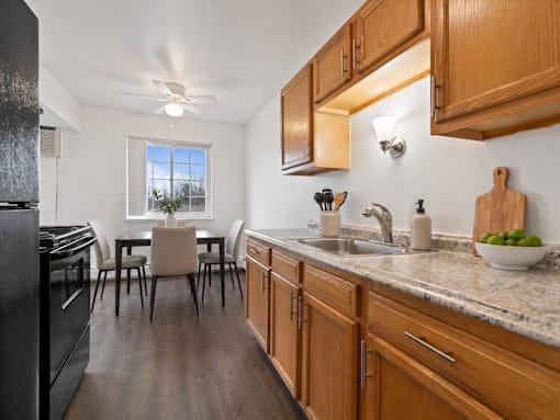A kitchen with wooden cabinets and a black fridge.