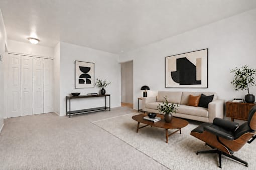 A modern living room with a white couch, a coffee table, and a chair.