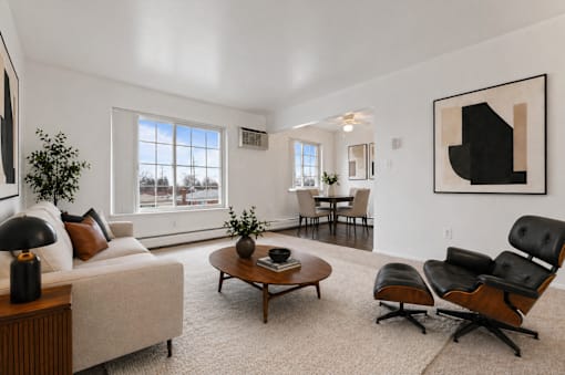 A living room with a white couch, a coffee table, and a large painting on the wall.