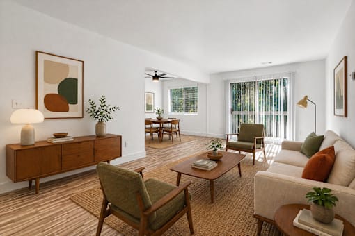 A living room with a brown rug and a wooden floor.