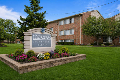 The Cove Apartments is a brick building with a sign in front.