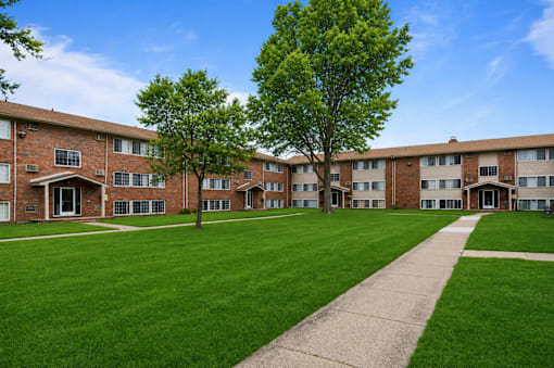 A grassy area in front of apartment buildings.