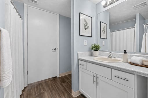 A bathroom with a white door, a white sink, and a white towel.