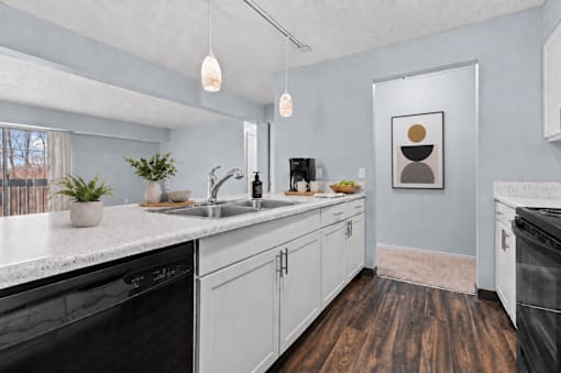 A kitchen with black appliances and white cabinets.