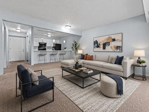 A living room with a white couch, a blue chair, and a coffee table.