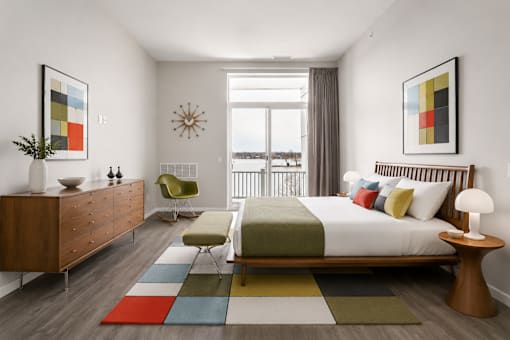 A bedroom with a large bed, a chair, and a dresser.