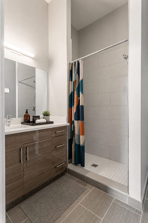 A bathroom with a shower curtain and a sink.