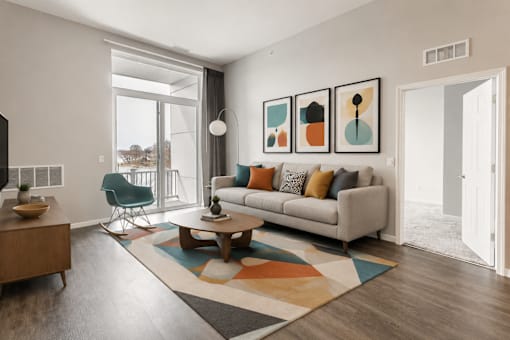 A living room with a sofa, a chair, a coffee table, and a rug.