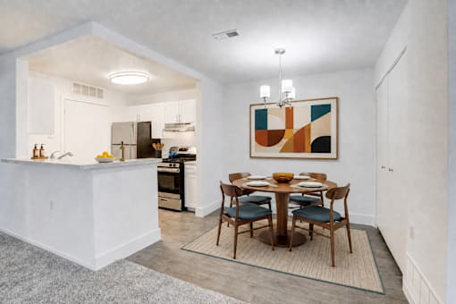 A modern kitchen with a dining table set for four.