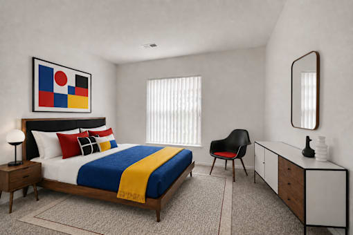 A bedroom with a bed, chair, and a painting on the wall.