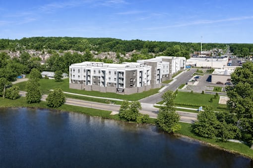 A large white building sits next to a body of water.