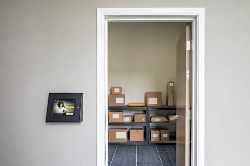 A doorway leads to a room with boxes on shelves.