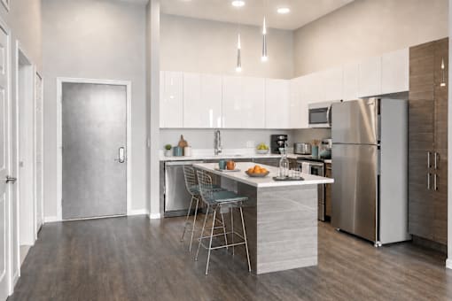 A modern kitchen with a center island and stainless steel appliances.