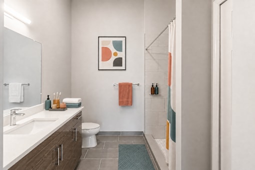A bathroom with a toilet, sink, and shower.