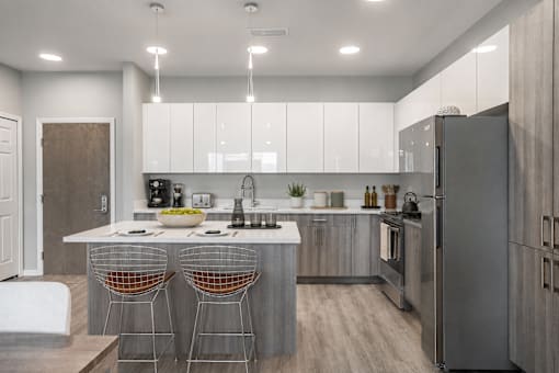 A modern kitchen with a white countertop and stainless steel appliances.