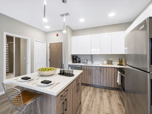 A modern kitchen with a white countertop and stainless steel appliances.