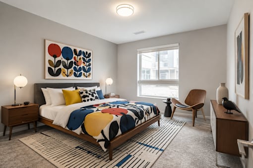 A bedroom with a large bed and a colorful abstract painting above it.