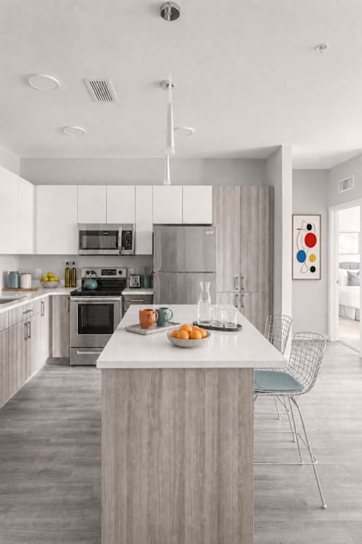 A modern kitchen with a large island and a dining area.