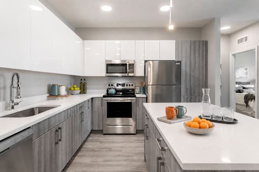 A modern kitchen with stainless steel appliances and white countertops.