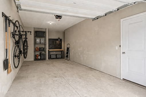 A room with a white door and a bicycle hanging on the wall.
