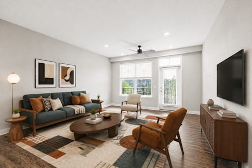 A living room with a couch, chairs, and a television.