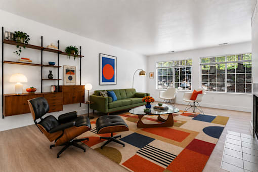 A living room with a green couch, a coffee table, and a rug.