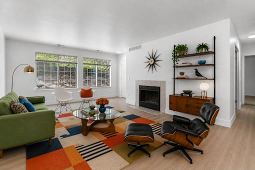 A living room with a green couch, a coffee table, and a fireplace.