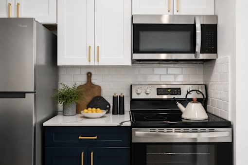 A kitchen with a stove, microwave, and refrigerator.