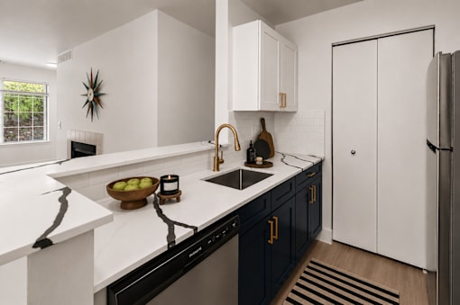 A modern kitchen with black cabinets and white countertops.
