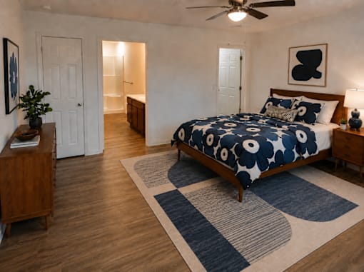 A bedroom with a bed, a ceiling fan, and a rug.