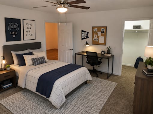 A bedroom with a bed, desk, and ceiling fan.