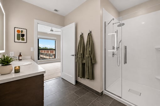 A bathroom with a white sink and a glass shower stall.
