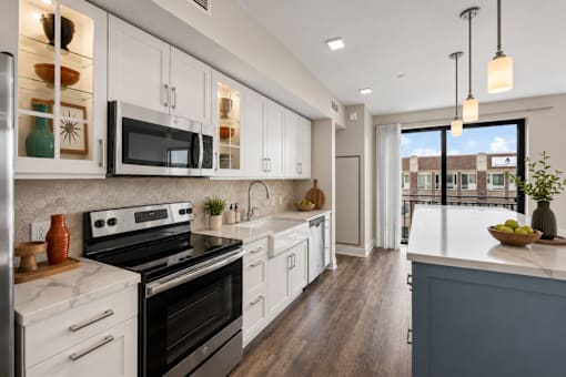 A modern kitchen with white cabinets and a black stove top oven.