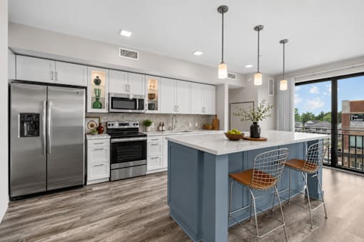 A modern kitchen with a blue island and stainless steel appliances.