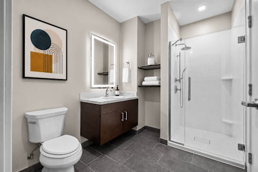 A bathroom with a toilet, sink, and shower.