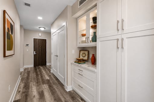 A hallway with a brown floor and white walls.