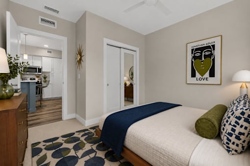 A bedroom with a bed, a dresser, and a framed picture on the wall.