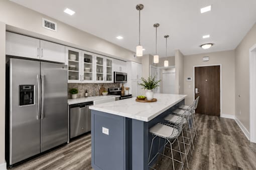 A modern kitchen with a large island and stainless steel appliances.