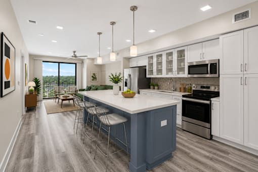 A modern kitchen with a blue island and white cabinets.