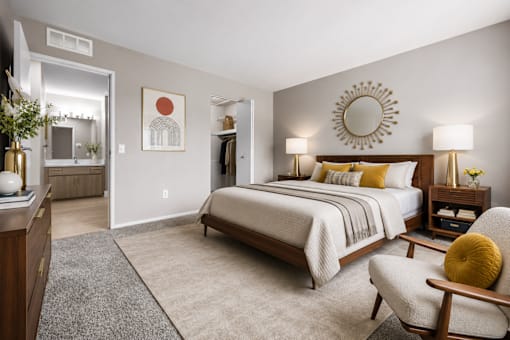 Modern bedroom with ensuite bathroom and walk-in closet at Village Club of Farmington Hills Apartments, Farmington Hills