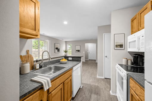 Modern kitchen with granite countertops and oak cabinets at Village Club of Farmington Hills Apartments, Farmington Hills, MI 48331