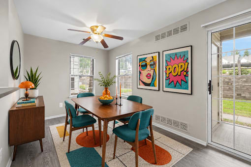 Dining room with midcentury modern furniture and pop art at Village Club of Farmington Hills Apartments, Farmington Hills, Michigan