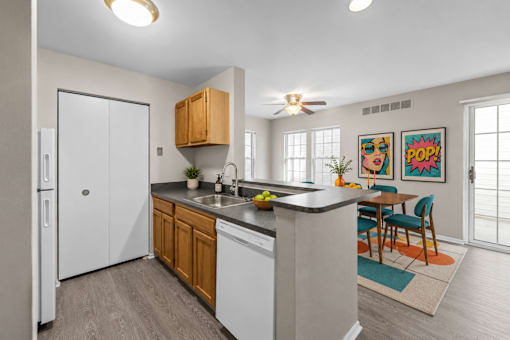 Open concept kitchen with breakfast bar and dining area at Village Club of Farmington Hills Apartments, Farmington Hills