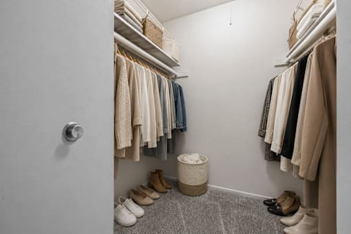 Walk-in closet with organized storage shelving at Village Club of Farmington Hills Apartments, Michigan