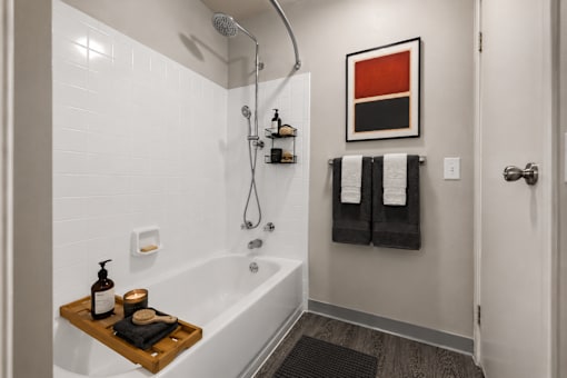 Modern bathroom with white subway tile and tub shower combo at Village Club of Farmington Hills Apartments, Michigan, 48331