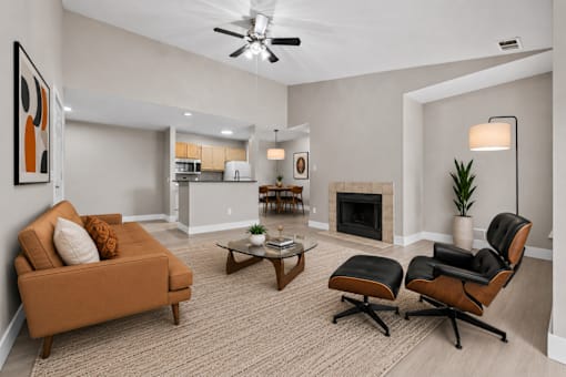 Open concept living room with modern furniture and fireplace at Village Club of Farmington Hills Apartments, Farmington Hills