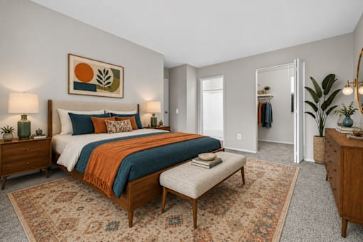 Spacious bedroom with walk-in closet and midcentury furnishings at Village Club of Farmington Hills Apartments, Michigan, 48331