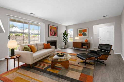 Carpeted living room with large window at Village Club of Farmington Hills Apartments, Farmington Hills, MI