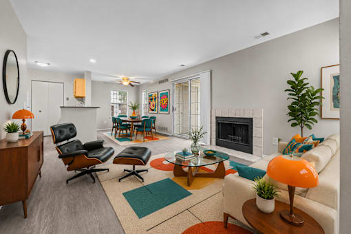 A living room with a fireplace and a chairs at Village Club of Farmington Hills Apartments, Farmington Hills, MI